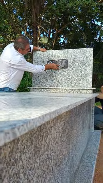Profissional da ArtPlacas realizando a instalação de uma placa em memorial de granito